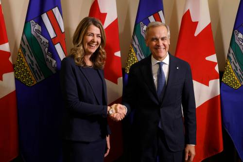 Prime Minister Mark Carney shakes hands with Alberta Premier Danielle Smith in Calgary on May 15. (The Canadian Press files)