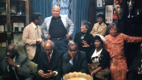 This image released by Neon shows, seated from left, Thomas Harvey, William Patterson, John Henrik Clarke, Mrs. J.B Matthews, and Louise Patterson, standing from left, Ernest Crichlow, Romare Bearden, and Ida Mae Cullen a scene from the documentary 