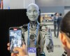 People take photos of an AI robot at the All In artificial intelligence conference Wednesday, Sept. 27, 2023 in Montreal. THE CANADIAN PRESS/Ryan Remiorz