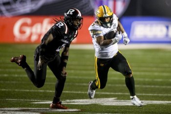 Edmonton Elks' running back Justin Rankin (5) evades a tackle by Ottawa Redblacks' defensive back CJ Reavis (8) during second half regular season CFL action in Ottawa, on Saturday, June 6, 2026. THE CANADIAN PRESS/Spencer Colby