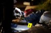 FILE - Policemen check the gun recovered from one of two unidentified drug suspects after they were shot dead by police while trying to evade a checkpoint in Quezon city, north of Manila, Philippines, Sept. 6, 2016. (AP Photo/Aaron Favila, File)