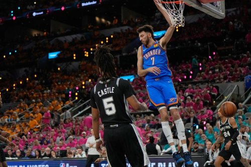 Oklahoma City Thunder center Chet Holmgren (7) hangs on the rim next to San Antonio Spurs guard Stephon Castle (5) after a dunk during the second half of Game 3 in the Western Conference finals NBA basketball playoffs series Friday, May 22, 2026, in San Antonio. (AP Photo/Ashley Landis)