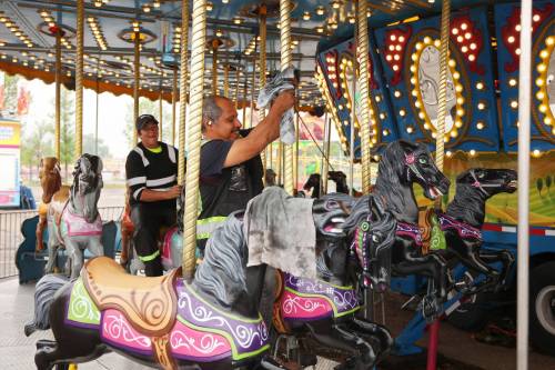 Midway workers polish the carousel ride in preparation for the 2026 Manitoba Summer Fair at the Keystone Centre grounds on Monday. The fair opens Wednesday and runs until Sunday. (Tim Smith/The Brandon Sun)