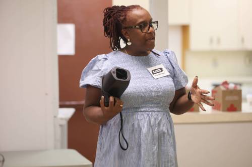Canadian National Institute for the Blind mobile hub and wellness lead La Toya Gibbons holds a Spot Vision Screener, a portable device that can detect potential eye conditions in approximately 90 seconds, during a visit at the Central Community Centre on Monday afternoon. (Abiola Odutola/The Brandon Sun)