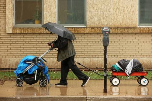 A pedestrian tries to stay dry under an umbrella while walking along Princess Avenue in the rain on Tuesday afternoon. (Tim Smith/The Brandon Sun)
