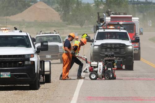Workers with the province create new rumble strips on Manitoba Highway 110 north of Richmond Avenue East on Tuesday as simultaneous work is done on the traffic light system at the intersection of Richmond and Highway 110. (Tim Smith/The Brandon Sun)