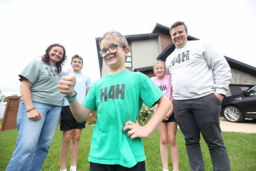 Holden Stewart (centre) gives the thumbs up surrounded by his family, including mother Jill, brother Hudson, sister Harper and father Derrick, outside their family home in Brandon on Friday afternoon. Holden was diagnosed with a rare neurological genetic disease in September 2021. The family is hosting a golf tournament next week to help raise funds for a cure. (Matt Goerzen/The Brandon Sun)