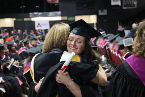 Office management graduate Marie Dunster hugs one of her former instructors during Assiniboine College&rsquo;s graduation ceremony on Friday morning at Assiniboine Credit Union Place. (Photos by Abiola Odutola/The Brandon Sun)