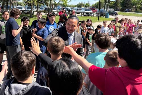 Premier Wab Kinew greets students outside Lord Selkirk Regional Comprehensive Secondary School in Selkirk on Tuesday. (Nicole Buffie/Winnipeg Free Press)