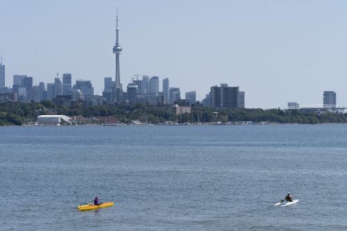 The CN Tower looms in the distance as a pair of kayakers paddle on Lake Ontario in Toronto, on Tuesday, Aug. 22, 2023. THE CANADIAN PRESS/Spencer Colby