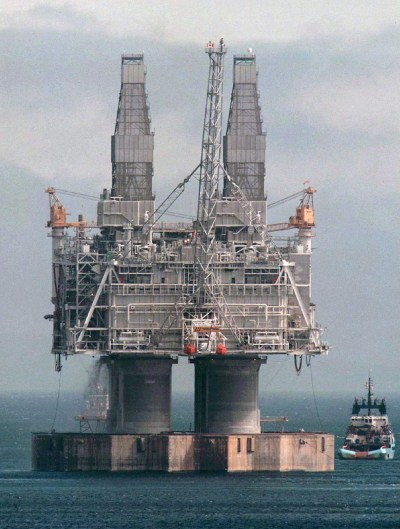 A tug positions itself near the base of the Hibernia platform in Bull Arm, N.L., Thursday, May 22, 1997. THE CANADIAN PRESS/Jonathan Hayward