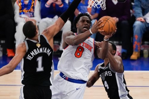 New York Knicks forward OG Anunoby (8) shoots between San Antonio Spurs forward Victor Wembanyama (1) and guard De'aaron Fox (4) during the first half of Game 4 of the NBA Finals basketball series, Wednesday, June 10, 2026, in New York. (AP Photo/Ross D. Franklin)