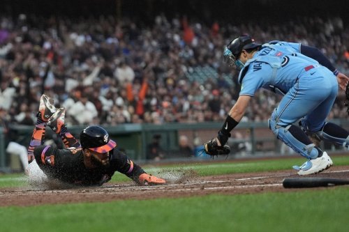 San Francisco Giants' Heliot Ramos, left, slides home to score against Toronto Blue Jays catcher Brandon Valenzuela during the fifth inning of a baseball game Tuesday, July 7, 2026, in San Francisco. (AP Photo/Jeff Chiu)