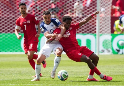 Bosnia-Herzegovina's Ivan Basic (13) and Canada's Jonathan David (10) vie for the ball during the second half of a World Cup Group B soccer match, in Toronto, on Friday, June 12, 2026. THE CANADIAN PRESS/Nathan Denette