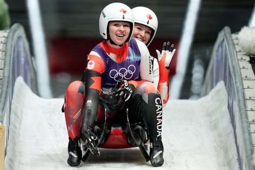Canada's Beattie Podulsky, left, and Kailey Allan, right, arrive at the finish during a women's doubles luge run at the 2026 Winter Olympics, in Cortina d'Ampezzo, Italy, Wednesday, Feb. 11, 2026. (AP Photo/Aijaz Rahi)
