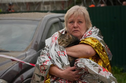 A woman carries her cat out of a damaged multi-storey apartment building following a Russian missile attack in Kyiv, Ukraine, earlier this week. (The Associated Press)