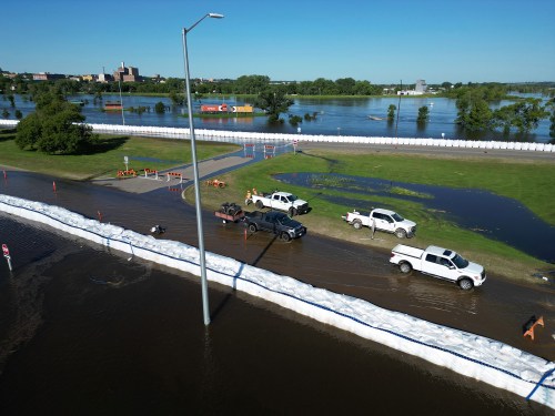 Dinsdale Park in Brandon is almost completely submerged by flood water on Sunday, while super-sandbags mostly protect First Street North from the floodwater.   (Tim Smith/The Brandon Sun)