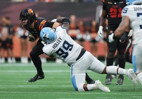 B.C. Lions quarterback Chase Brice (7) is tackled by Toronto Argonauts' Ralph Holley (99) as he carries the ball during the first half of a CFL game, in Vancouver, on Saturday, July 25, 2025. THE CANADIAN PRESS/Darryl Dyck