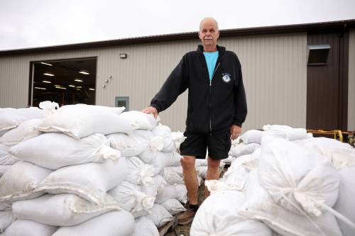 Minnedosa Mayor Ken Cameron stands among sandbags filled by volunteers on Friday. The Little Saskatchewan River is expected to continue to rise as water from recent rains in the area makes its way into the river and downstream. (Photos by Tim Smith/The Brandon Sun)