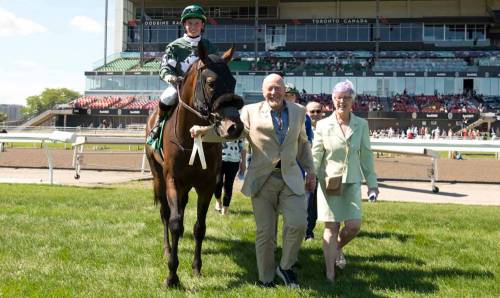 Ross McKague and his wife Brenda walk their horse Brachetto (5), with jockey Ryan Munger on board, into the walking ring in late June. Despite a bad back, the 79-year-old McKague is certainly enjoying the moment. (Michael Burns/Woodbine Photo)