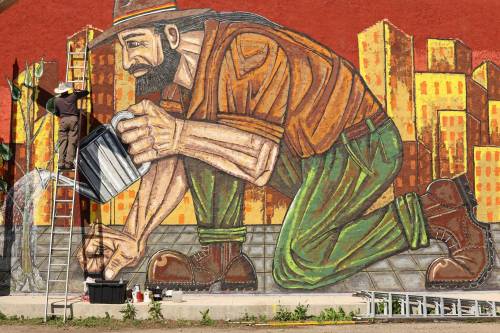 Miguel Rodriguez works on his mural, &ldquo;Building Brandon,&rdquo; on the side of the New System Store building along Rosser Avenue just west of Sixth Street on Friday. (Photos by Tim Smith/The Brandon Sun)