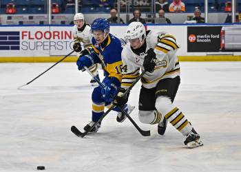 Brandon Wheat Kings defenceman Gio Pantelas (84) and Saskatoon Blades forward Cooper Williams (16) battle for the puck during Western Hockey League action at SaskTel Centre on March 18, 2026. Pantelas will be plying his trade for the Penticton Vees next season but treasures his time in Brandon. (Rick Elvin/Saskatoon Blades)