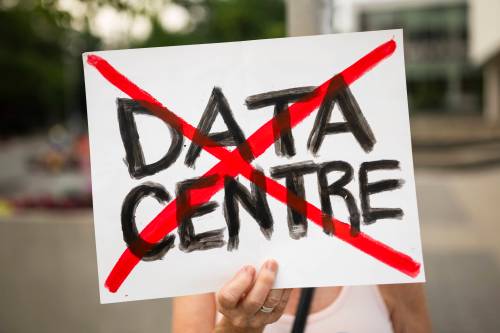 A person in opposition to AI data centres demonstrates outside city hall in Hamilton on Wednesday. Alex Passey writes that it&rsquo;s time to pop the hype bubble that surrounds artificial intelligence. (The Canadian Press)