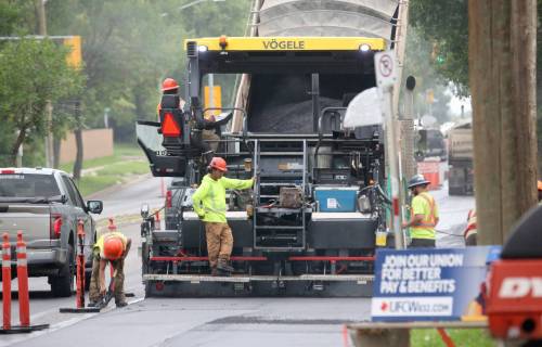 A dump truck feeds hot asphalt into a pacing machine that spreads it evenly along the right lane of westbound Richmond Avenue on Tuesday afternoon. The work is taking place on a 1.6-kilometre stretch between Second and 18th streets, at a cost of $5.97 million. (Matt Goerzen/The Brandon Sun)