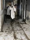 Workers mop up the mud inside the Dauphin hospital on July 16. (Supplied)