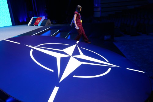 A woman walks down steps next to the NATO logo during the NATO Defence Industry Forum at the NATO summit in Ankara, Turkey, Tuesday, July 7, 2026. (AP Photo/Hussein Malla)