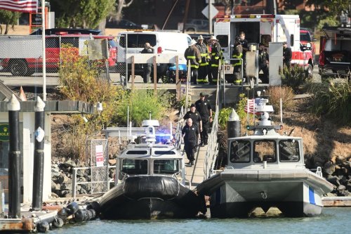 Emergency crews gather at a dock near the site of a pontoon boat fire on Tuesday, July 14, 2026, in San Francisco. (AP Photo/Noah Berger)