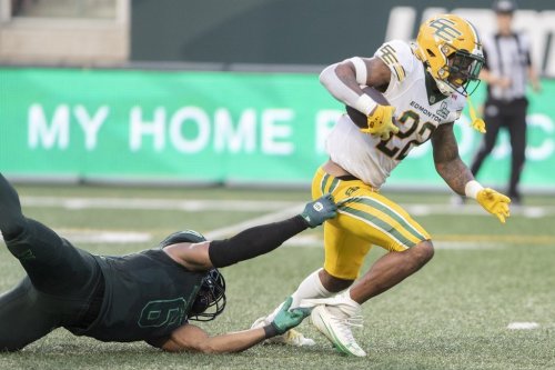 Edmonton Elks running back Javon Leake (22) runs the ball as Saskatchewan Roughriders linebacker Jameer Thurman (6) tries to make a tackle during first half CFL football action in Regina on Thursday, July 23, 2026. THE CANADIAN PRESS/Kayle Neis