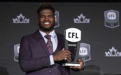 Most outstanding defensive player, defensive Linesman Lorenzo Mauldin IV of the Ottawa Red Blacks, holds up his trophy during the CFL Awards in Regina, Thursday, Nov. 17, 2022. THE CANADIAN PRESS/Paul Chiasson