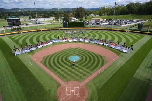 The 20 Little League teams from around the world competing in the 2023 Little League World Series baseball tournament line the infield at Volunteer Stadium during the opening ceremony in South Williamsport, Pa., Wednesday, Aug. 16, 2023. (AP Photo/Gene J. Puskar)