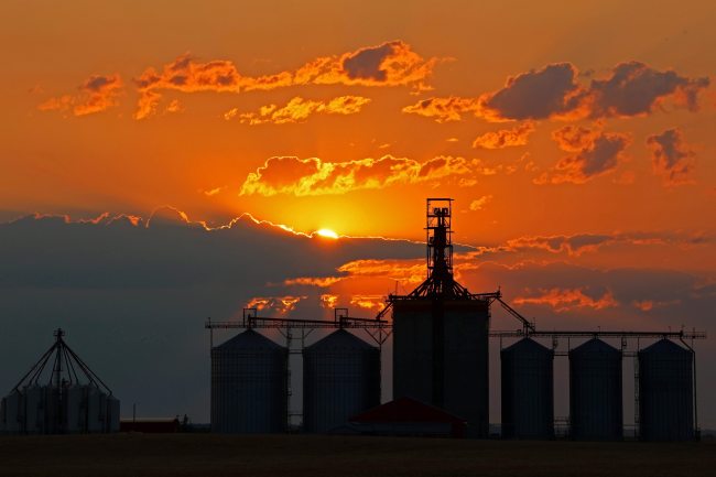 The sun rises through a bank of clouds in the east behind the Richardson Pioneer grain terminal in Kemnay on Monday morning. (Tim Smith/The Brandon Sun)
