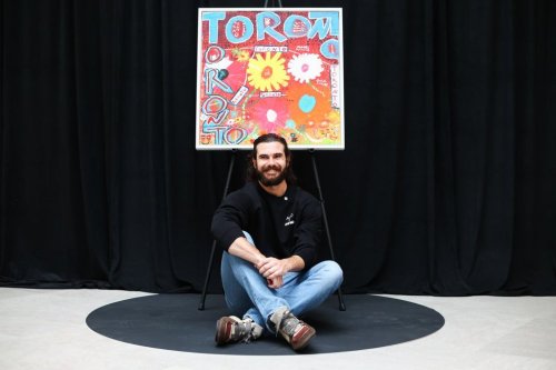 Toronto Blue Jays pitcher Dylan Cease sits under his painting during an event at the Art Gallery of Ontario in Toronto, Tuesday, August 25, 2026. THE CANADIAN PRESS/Cole Burston