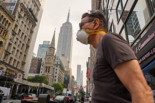 A person wearing a mask walks past the Empire State Building in New York last month during an air quality health advisory due to wildfire smoke. U.S. President Donald Trump and other Republicans have blamed Canada for smoke spreading across some northern U.S. states. (The Associated Press files)