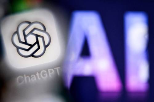 A photo taken in September 2025, shows the letters AI for Artificial Intelligence on a laptop screen (right) next to the logo of the ChatGPT application on a smartphone screen. AI&rsquo;s benefits to the workplace aren&rsquo;t as advertised. (Tribune News Service)