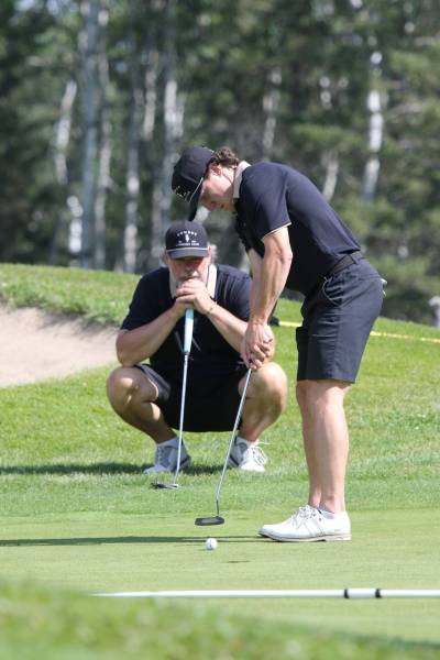 Riese Gaber putts while Scott McCallum watches during the Tamarack men';s scramble final at Clear Lake Golf Course on Saturday. (Thomas Friesen/The Brandon Sun)