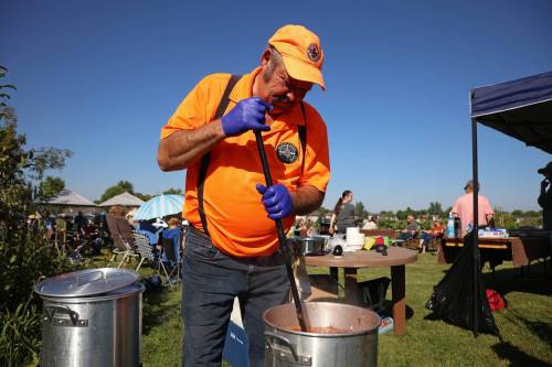 Brian Fowell, volunteer garden co-ordinator for the Hummingbird Community Garden at 26th Street and Maryland Avenue, stirs one of two big pots of stone soup, created with vegetables from some of the over 400 garden plots that make up the community garden during an event on Thursday evening. Fowell and his wife, Paulette, have been organizing the yearly event for close to 20 years. (Tim Smith/The Brandon Sun)