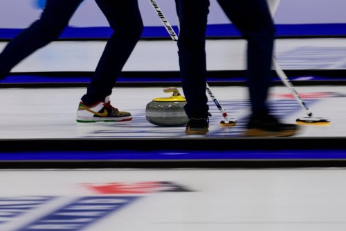 Athletes sweep the ice as a curling stone slides down the sheet before the bronze-medal game between the United States and Scotland at the world men's curling championship on April 4, 2026, in Ogden, Utah. (AP Photo/Tyler Tate)