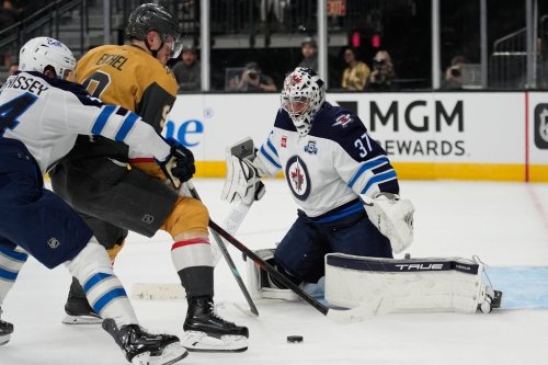 Vegas Golden Knights centre Jack Eichel (9) attempts a shot on Winnipeg Jets goaltender Connor Hellebuyck (37) during the second period of an NHL hockey game Monday, April 13, 2026, in Las Vegas. (AP Photo/John Locher)