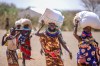 Women walk home after receiving food aid from the World Food Programme (WFP) and World Vision Kenya in Nadunga Village, Turkana County, Kenya, Friday, Feb. 6, 2026. (AP Photo/Patrick Ngugi)