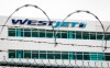 The WestJet headquarters building is seen through razor wire as WestJet flight attendants hold a 