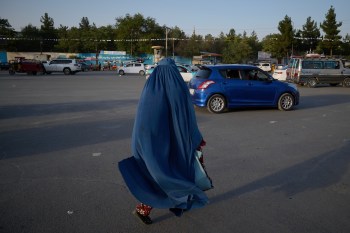 A woman wearing a burqa walks along a street on the eve of the fifth anniversary of the U.S. withdrawal and the start of Taliban rule in Kabul, Afghanistan, Friday, Aug. 14, 2026. (AP Photo/Nava Jamshidi)