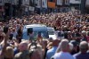 Fans of singer Bonnie Tyler line the streets as her coffin is transported in a hearse back to her former home ahead of her funeral, in Mumbles, Wales, Saturday, Aug. 15, 2026. The Total Eclipse Of The Heart musician, whose real name was Gaynor Hopkins, died in hospital in Portugal on July 8 at the age of 75. (AP Photo/Alastair Grant)