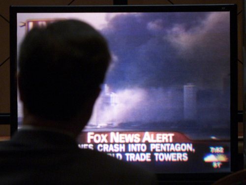 A man is silhouetted as he watches a television on Sept. 11, 2001 in Edmonton, showing smoke covering the downtown area of New York City after two separate planes crashed into the World Trade Center.  (CP PHOTO/Adrian Wyld)