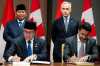 Indonesian Minister of Trade Budi Santoso, front-left, and Minister of International Trade Maninder Sidhu, front-right, take part in a signing ceremony during a working visit on Parliament Hill in Ottawa, on Wednesday, Sept. 24, 2025. THE CANADIAN PRESS/Spencer Colby