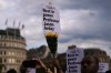 FILE - People attending a vigil held by Stand Up to Racism, in memory of late University of Cambridge professor Jason Arday, hold up signs at Trafalgar Square in London, on Aug. 17, 2026. (AP Photo/Kirsty Wigglesworth, File)
