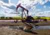A pumpjack draws out oil and gas from a well head with a canola field in the background near Cremona, Alta., Tuesday, July 15, 2025. Canada has the third largest oil reserves in the world and is the world's fourth largest oil producer. THE CANADIAN PRESS/Jeff McIntosh